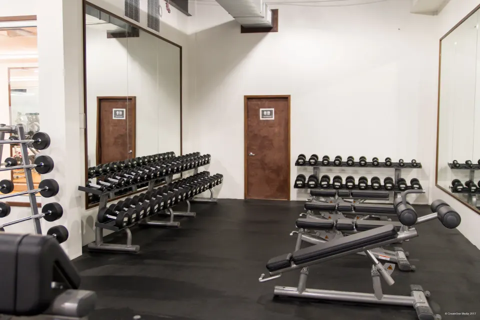 Fitness room with dumbbell racks, mirrors, and benches at Royal St. Kitts Hotel.