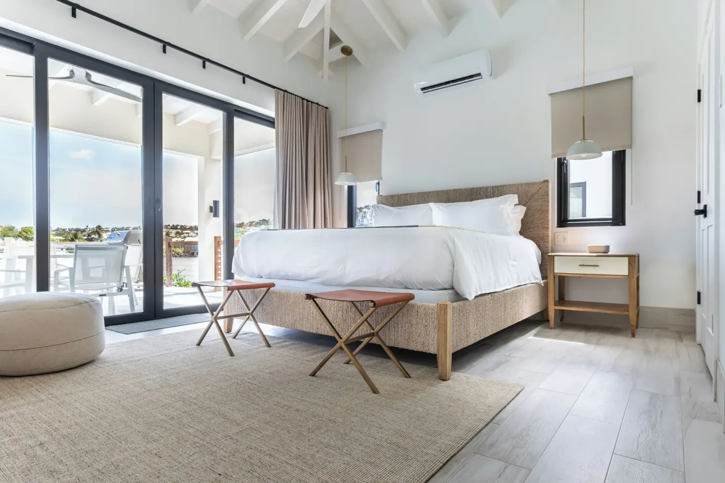 King bed guest room with balcony doors and vaulted ceiling at Royal St. Kitts Hotel.