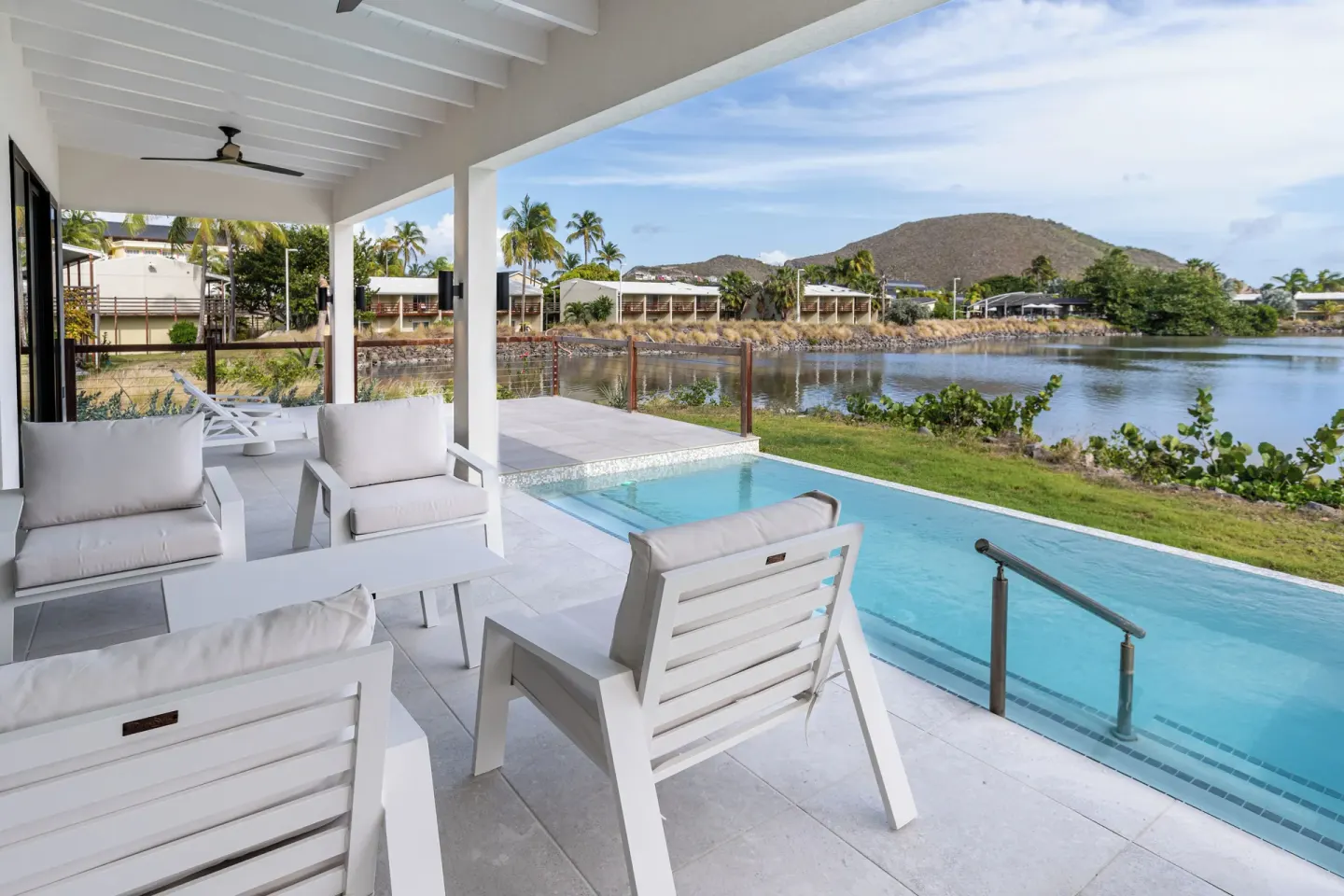 Covered patio with lounge chairs, private pool, and lagoon view at Royal St. Kitts Hotel.