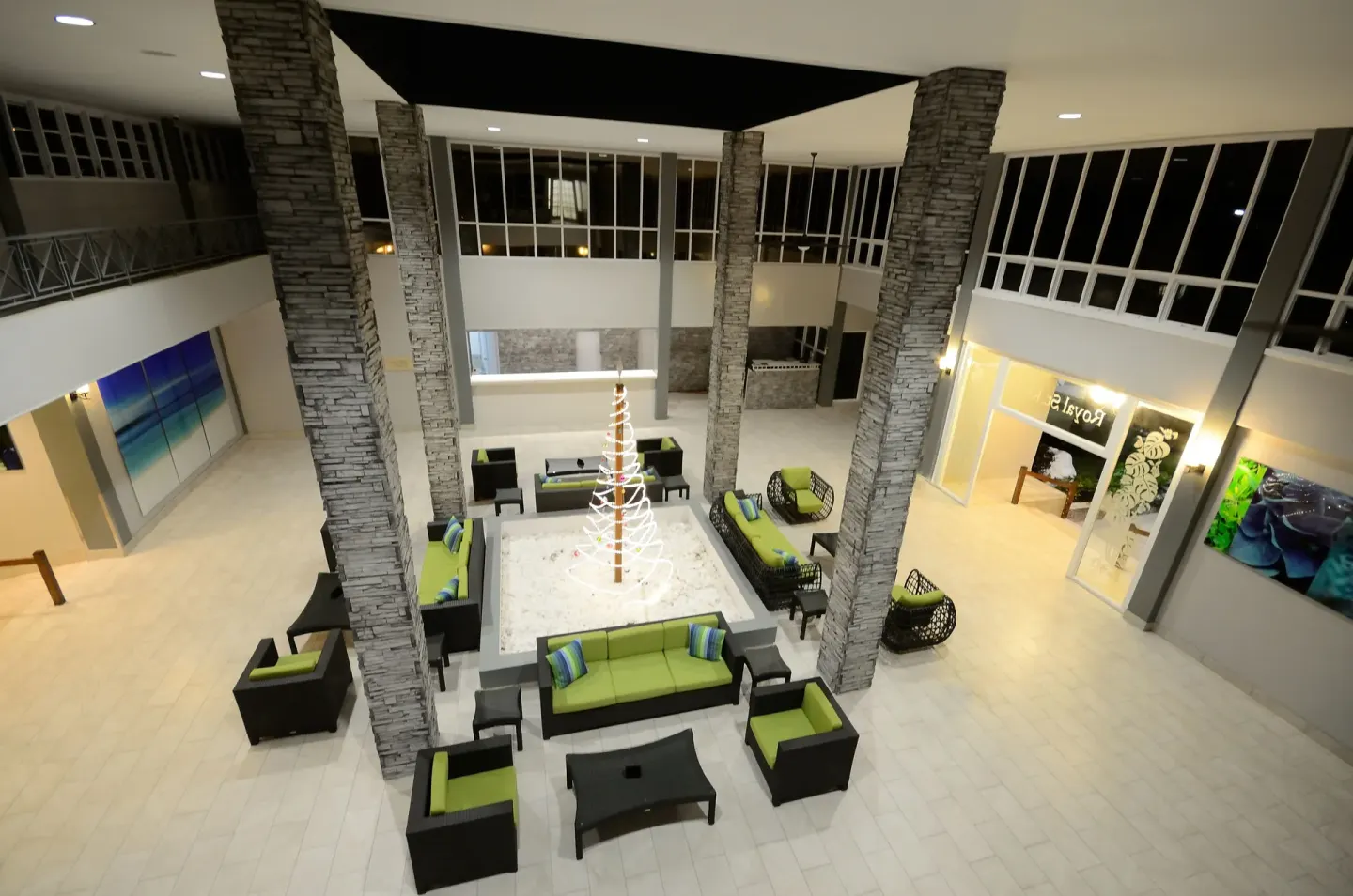 Lobby seating area with stone columns and green cushions at Royal St. Kitts Hotel.
