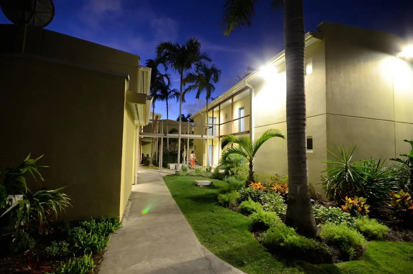Night walkway through landscaped resort buildings at Royal St. Kitts Hotel.