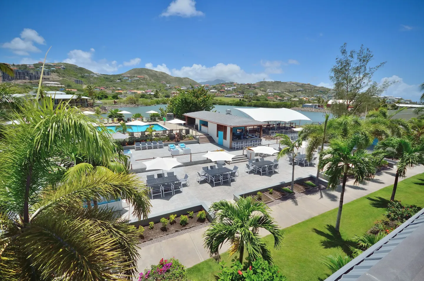 Resort terrace, pool area, palms, and lagoon view at Royal St. Kitts Hotel.