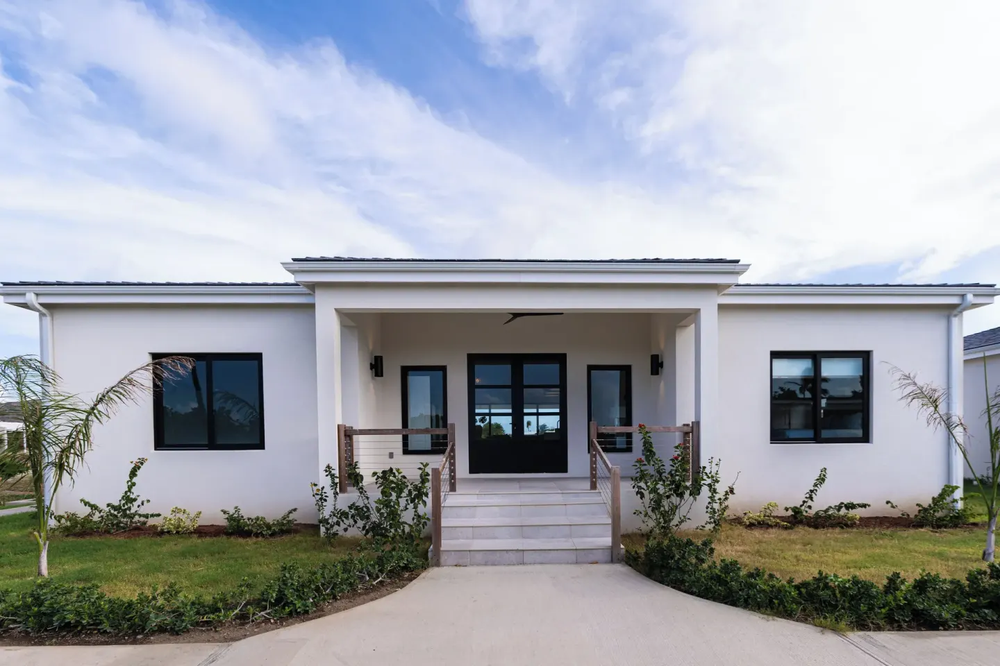 White resort villa entrance with landscaped walkway at Royal St. Kitts Hotel.