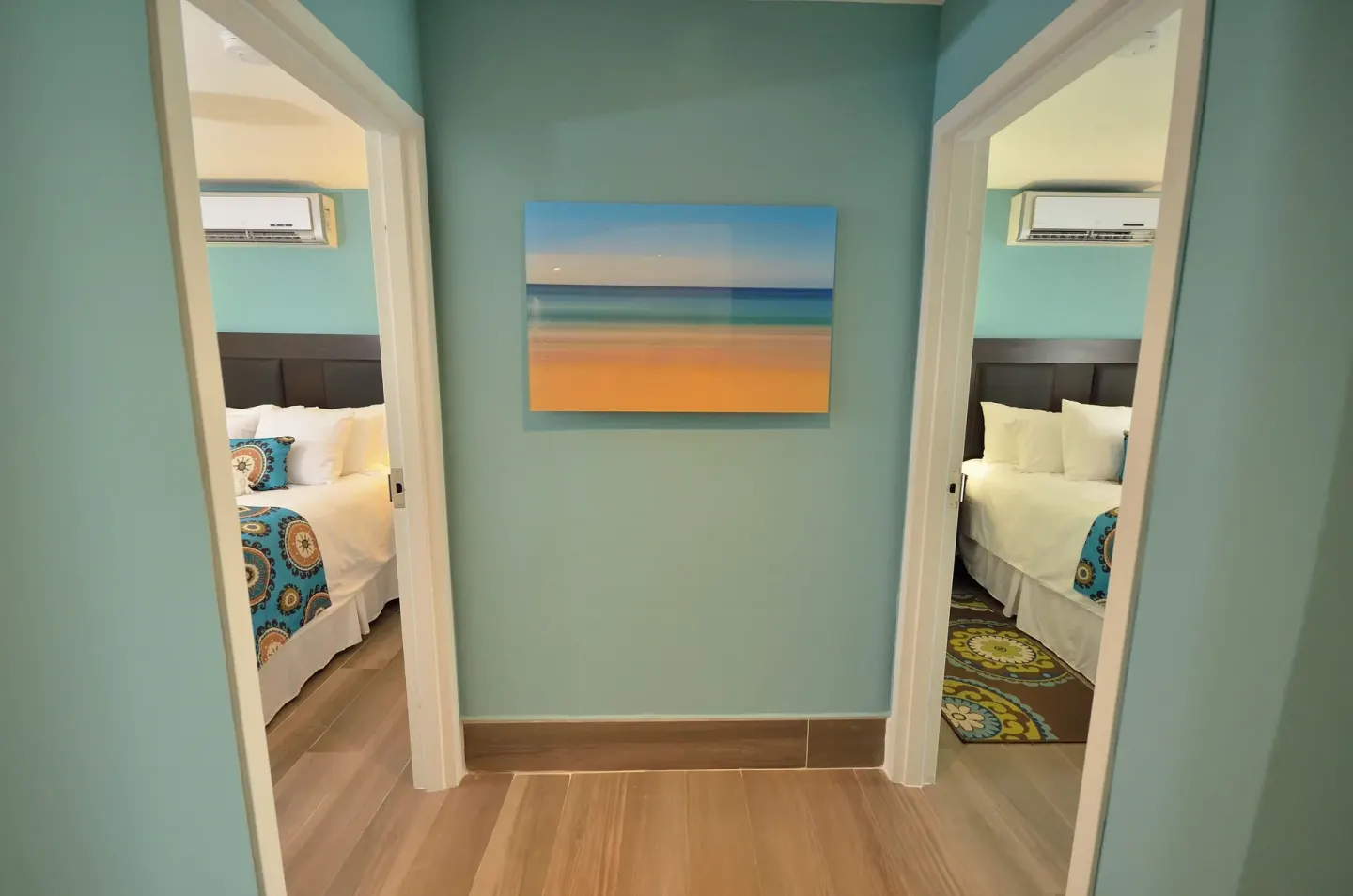 Two-bedroom suite hallway at Royal St. Kitts Hotel showing doorways to two bedrooms with white beds.
