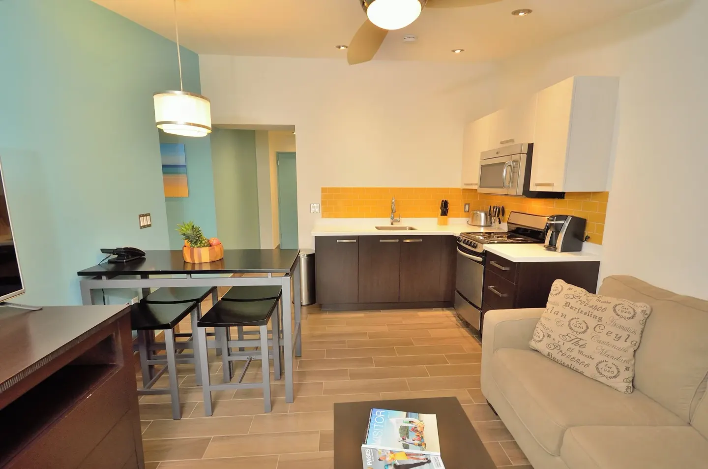 Two-bedroom suite living area and kitchen at Royal St. Kitts Hotel with sofa, dining table, and appliances.