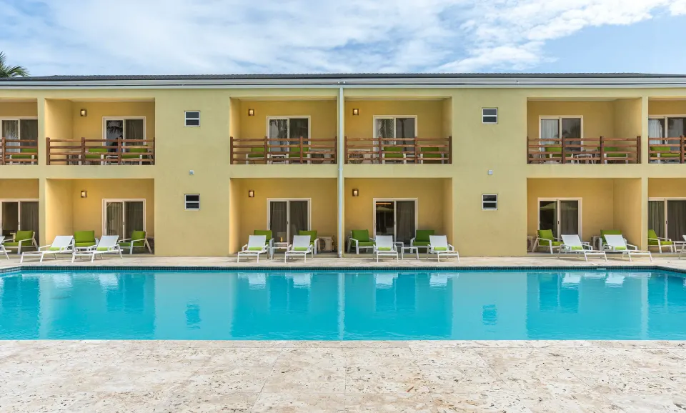 Poolside room building with balconies and loungers at Royal St. Kitts Hotel.