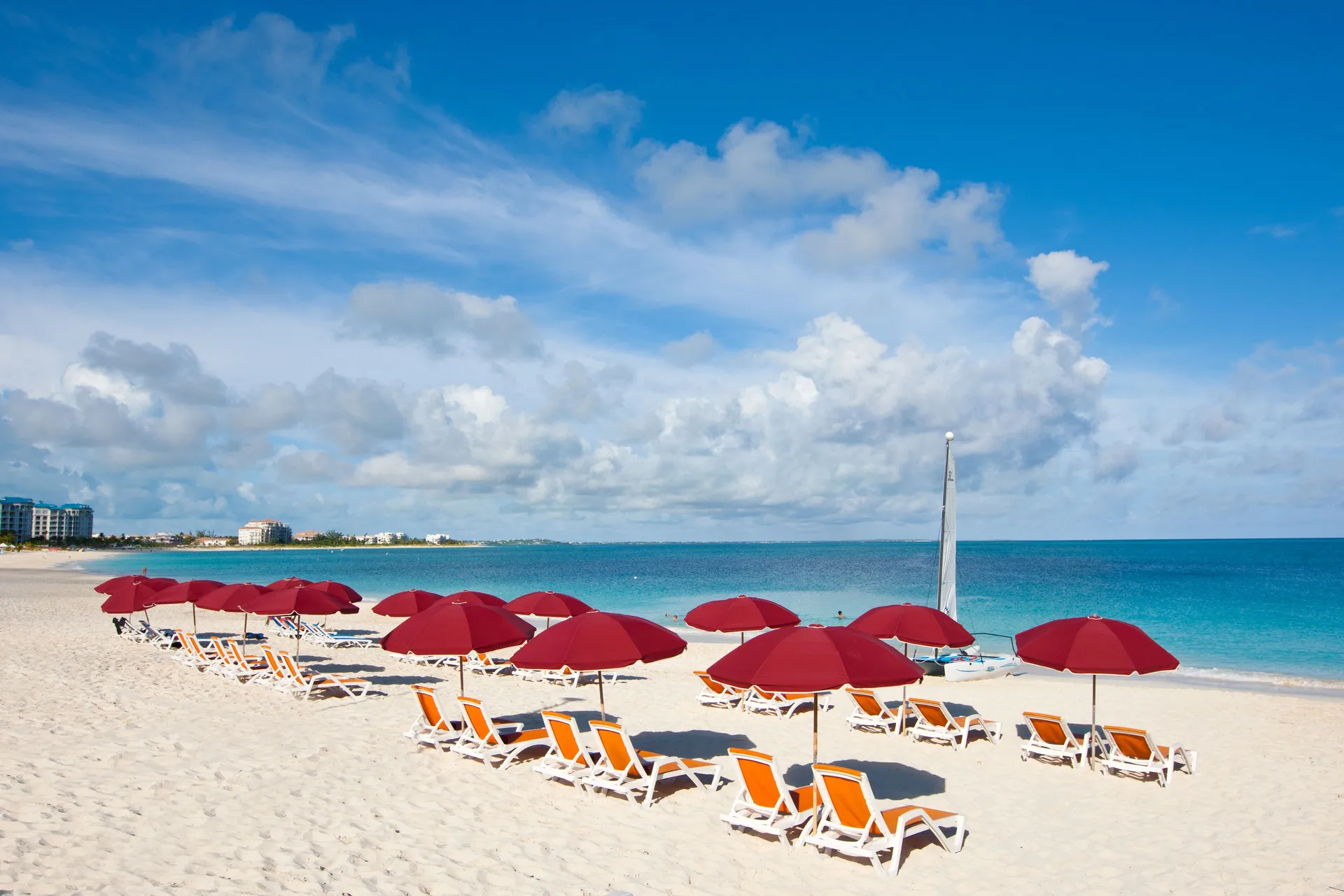 Rows of red umbrellas and lounge chairs on the beach at Royal West Indies Resort.