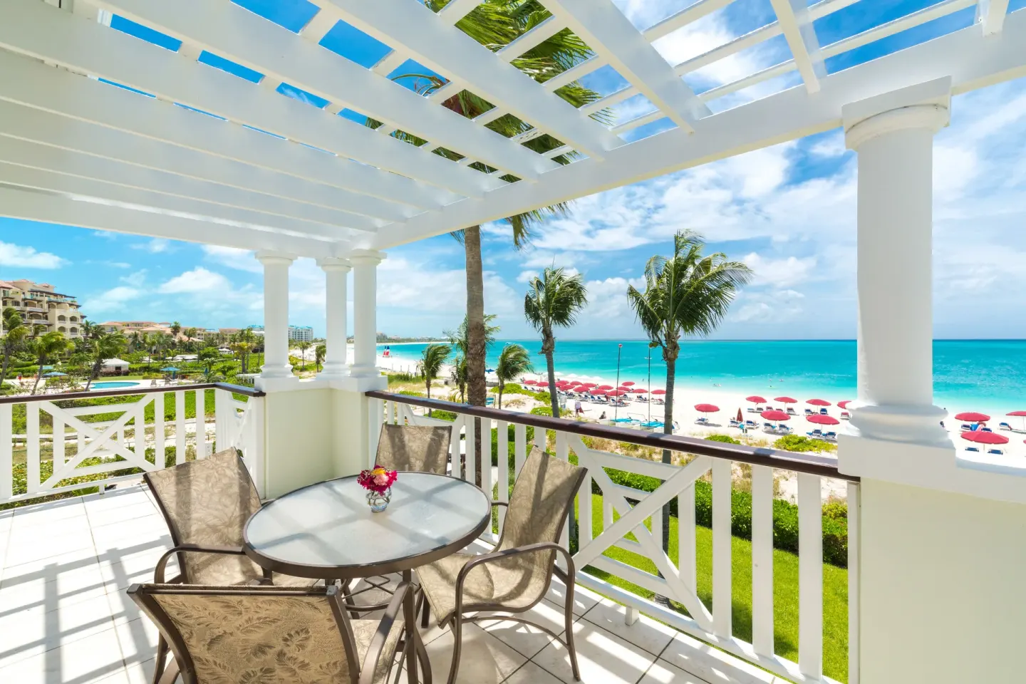 Covered balcony with table and chairs overlooking the beach at Royal West Indies Resort.