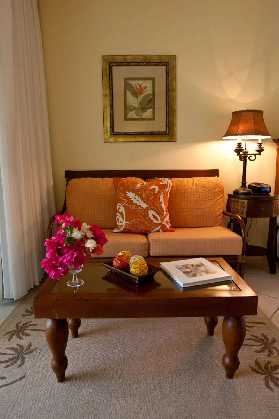 Guest room sitting area with orange sofa and wood coffee table at Royal West Indies Resort.