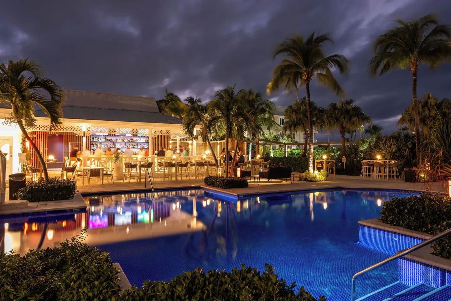 An illuminated pool and bar patio at night at Royal West Indies Resort.