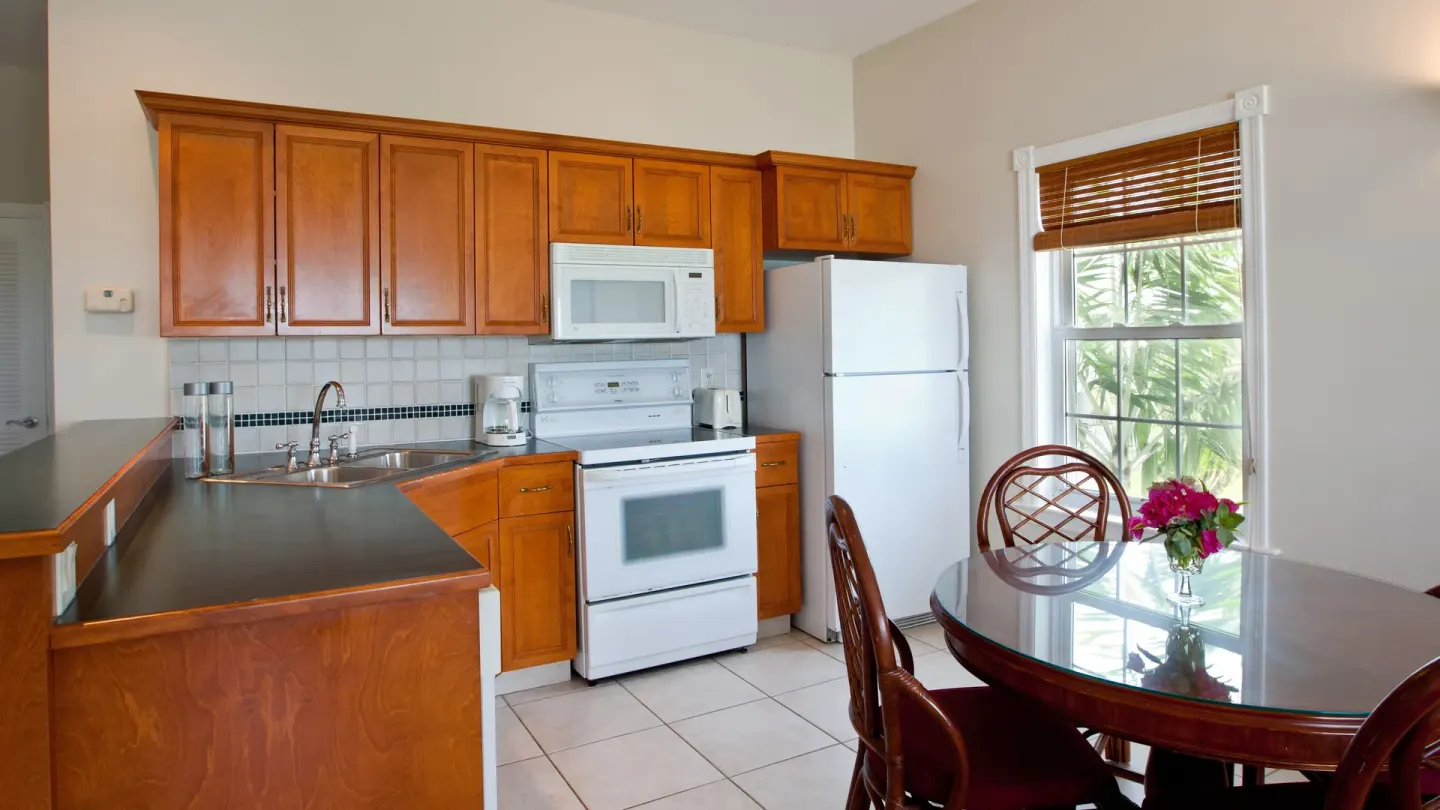 Kitchen and dining area with wood cabinets at Royal West Indies Resort.