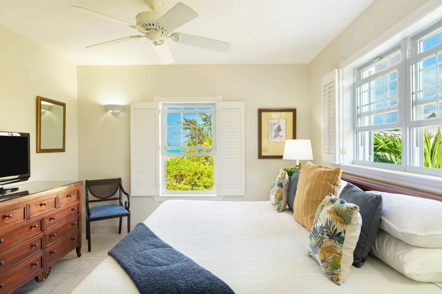 One bedroom garden view condo bedroom with king bed and wood dresser at Royal West Indies Resort.