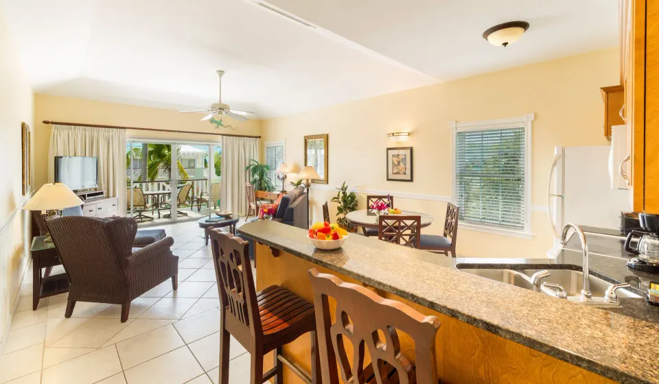 One bedroom condo kitchen bar and living room opening to balcony at Royal West Indies Resort.