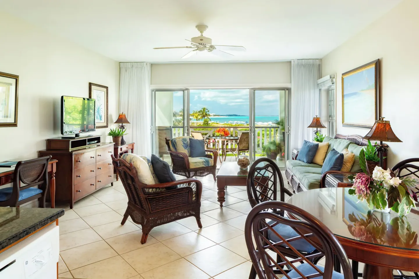 One bedroom condo living and dining area with balcony ocean view at Royal West Indies Resort.