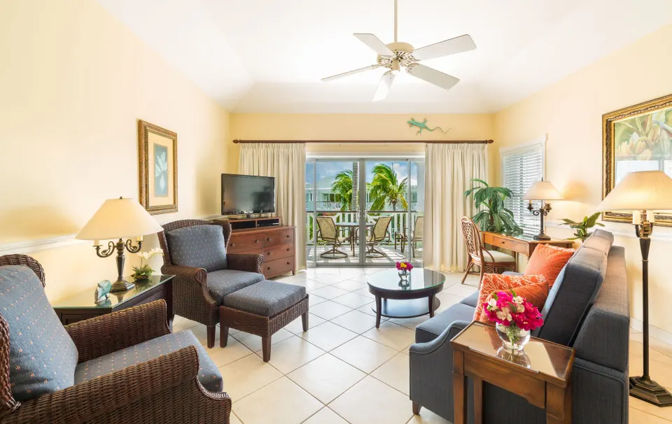 One bedroom garden view condo living room with sofa and balcony doors at Royal West Indies Resort.