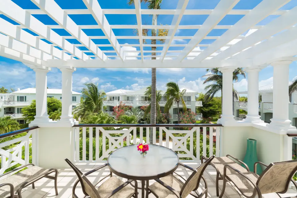 Studio Botanical View balcony with pergola, table, chairs and garden view at Royal West Indies Resort.