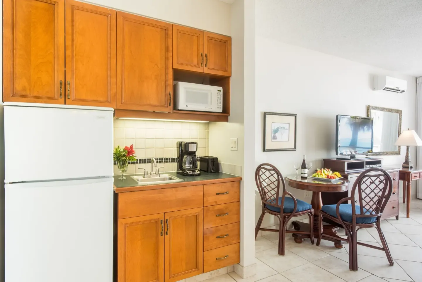 Studio Botanical View kitchenette with refrigerator, microwave, sink and dining table at Royal West Indies Resort.