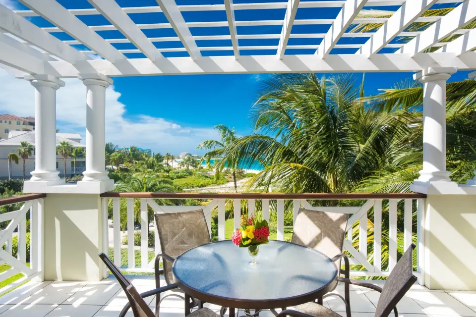 Studio ocean view balcony with table and palms at Royal West Indies Resort.