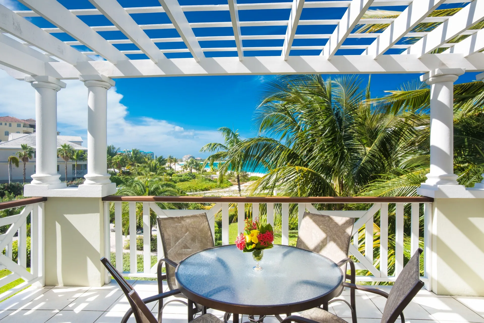 Studio ocean view balcony with table and palms at Royal West Indies Resort.