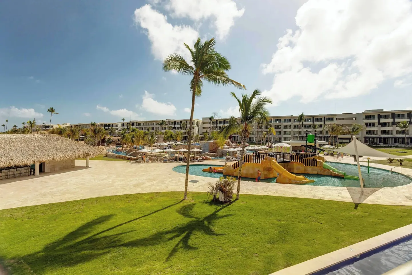Family pool area with slides and palms at Royalton Bavaro Resort & Casino.