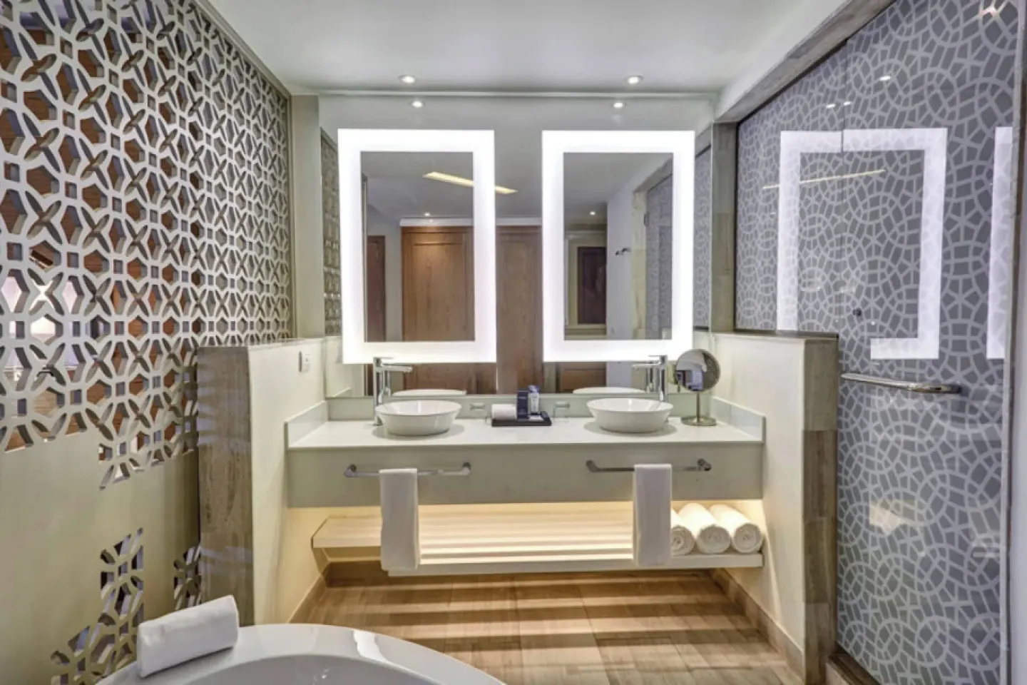 Bathroom with double vanity and glass shower at Royalton Bavaro Resort & Casino.