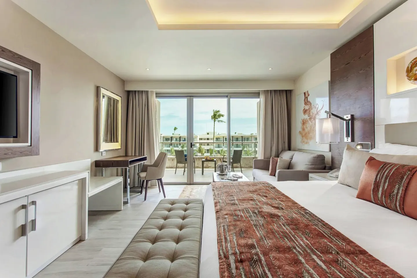 Guest room with king bed, sofa and balcony view at Royalton Bavaro Resort & Casino.