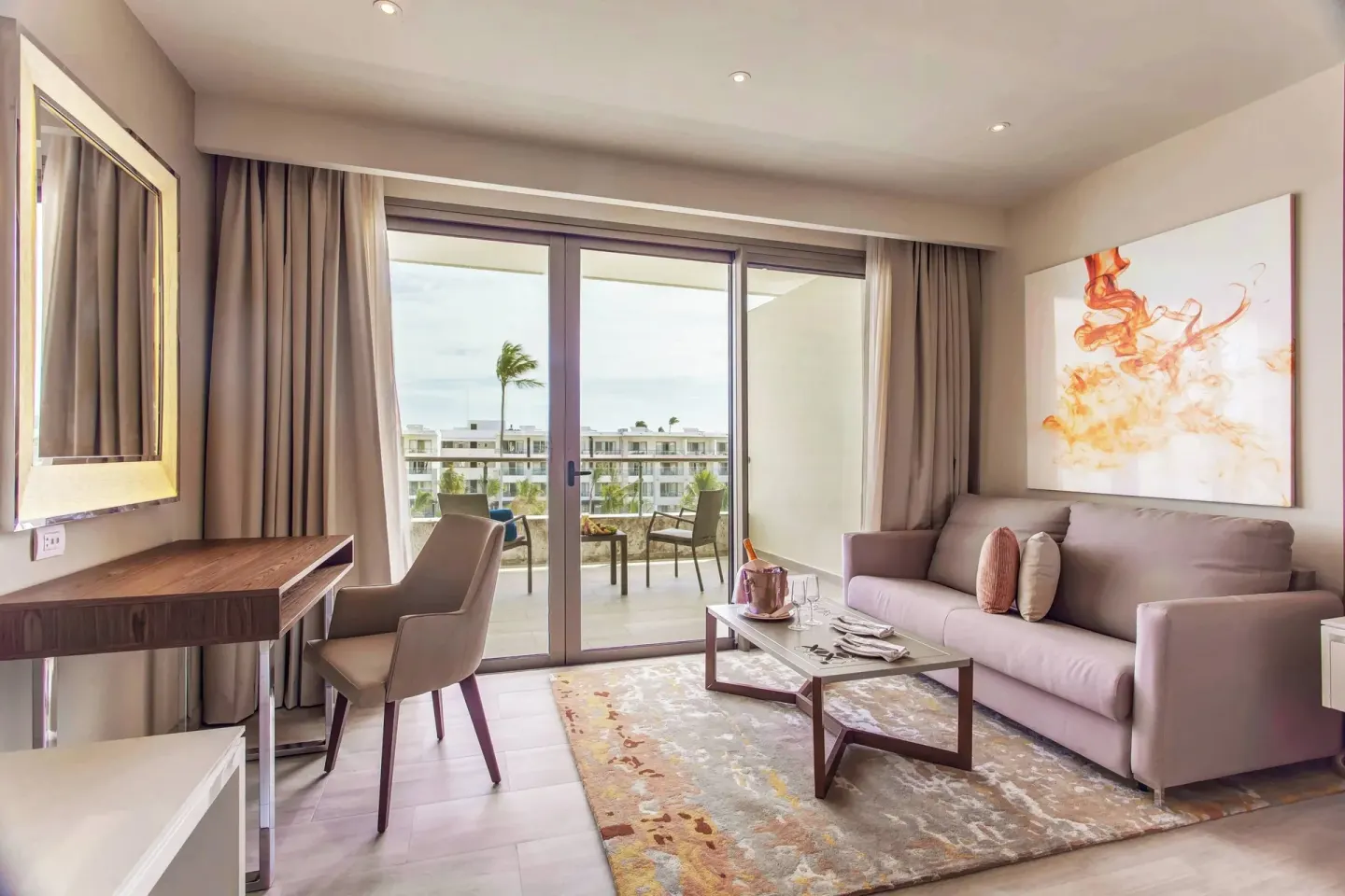 Guest room sitting area with balcony view at Royalton Bavaro Resort & Casino.
