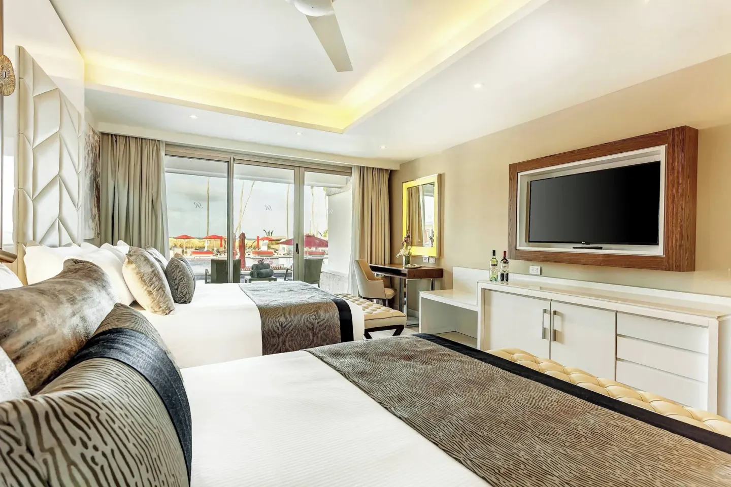 Guest room with two beds and sliding doors to the pool at Royalton Bavaro Resort & Casino.