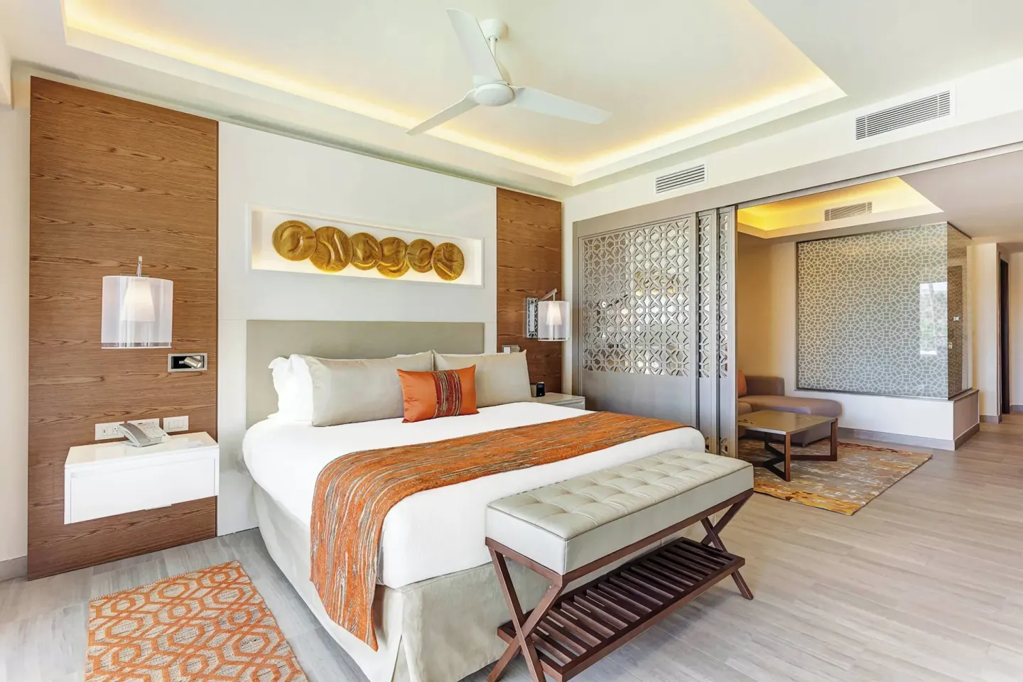 Guest suite with king bed and sitting area at Royalton Bavaro Resort & Casino.