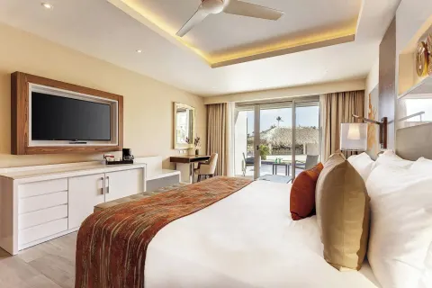 King bed guest room with patio doors at Royalton Bavaro Resort & Casino.
