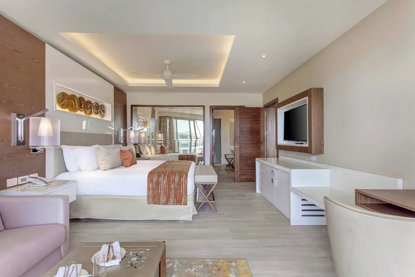 King bed guest room with sofa and work desk at Royalton Bavaro Resort & Casino.