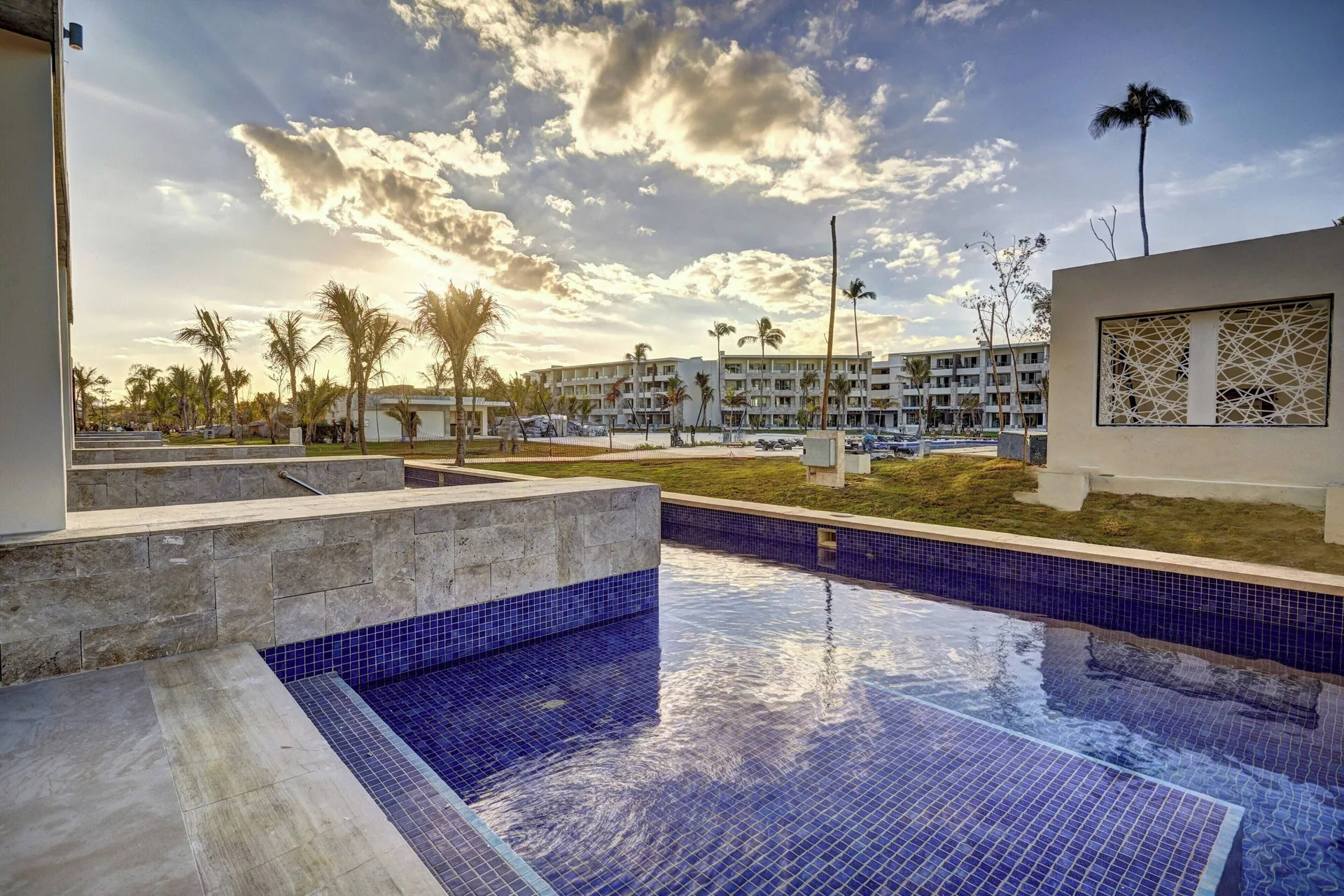 Private tiled pool with resort buildings and palms at Royalton Bavaro Resort & Casino.