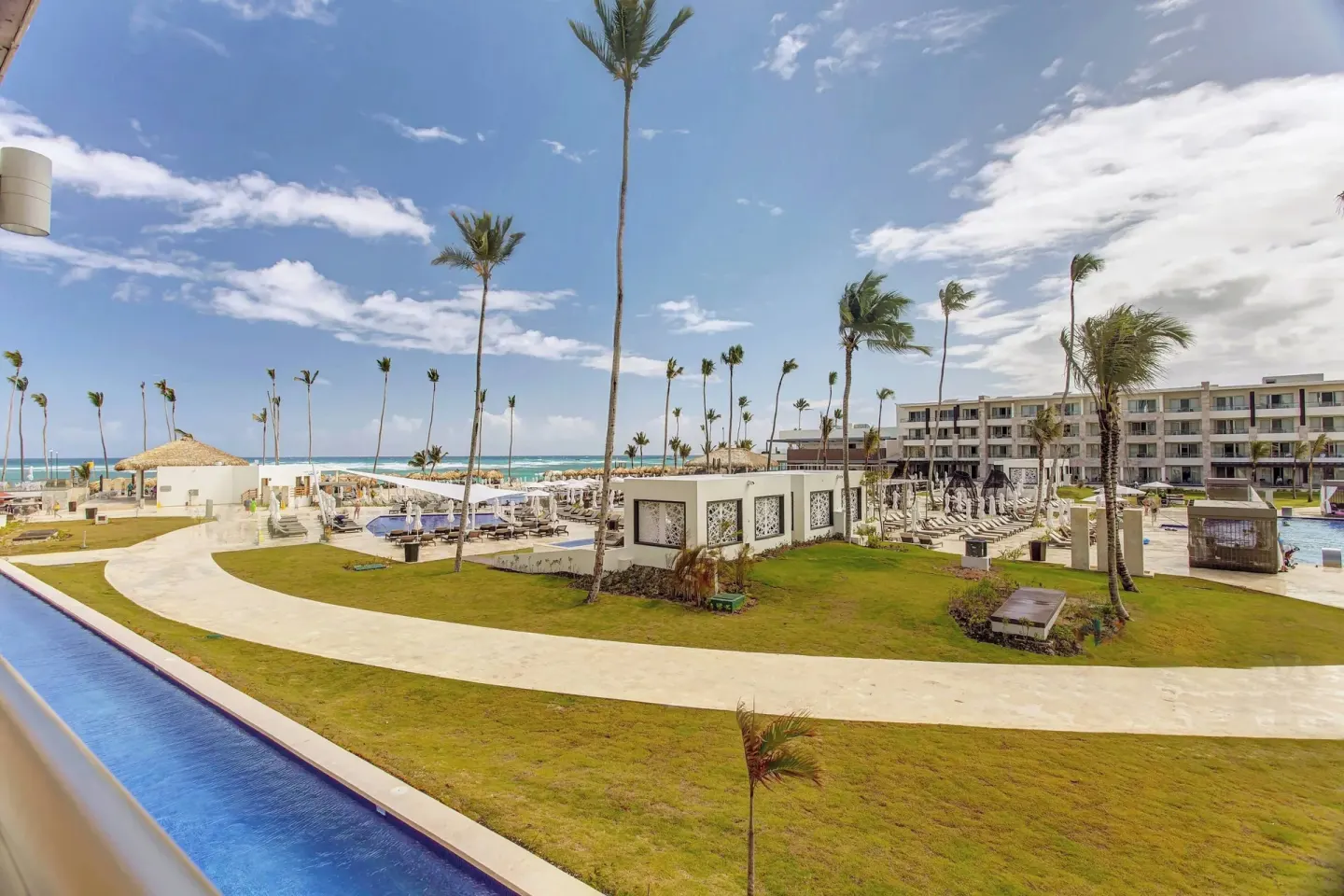 Resort grounds with pools, palms, lawns, and ocean beyond at Royalton Bavaro Resort & Casino.