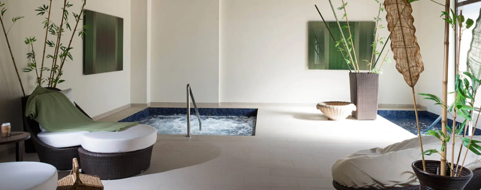 A spa relaxation area with loungers, plants, and bubbling pools at Royalton Bavaro Resort & Casino.