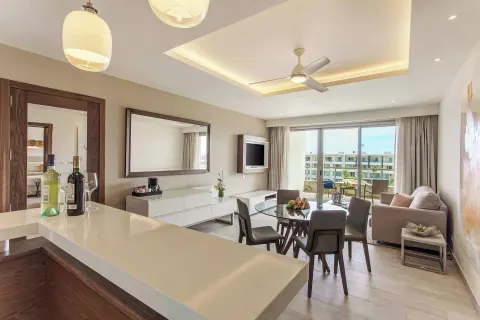 Bright suite living and dining area with balcony at Royalton Bavaro Resort & Casino.