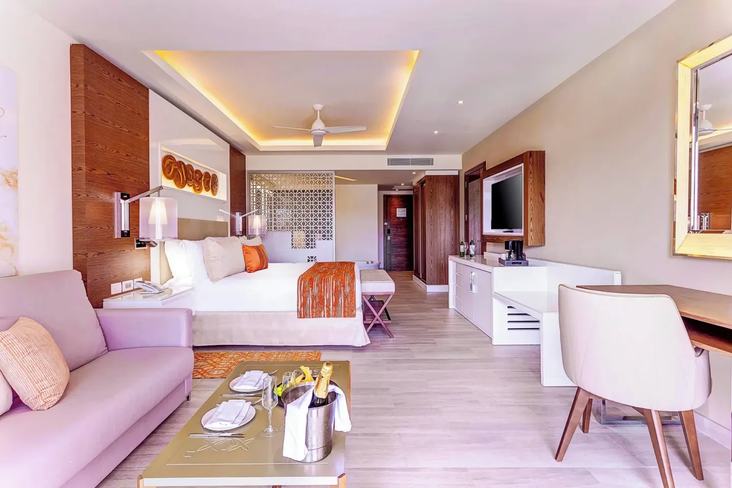 Spacious king bed suite with sofa, desk, and coffee table at Royalton Bavaro Resort & Casino.