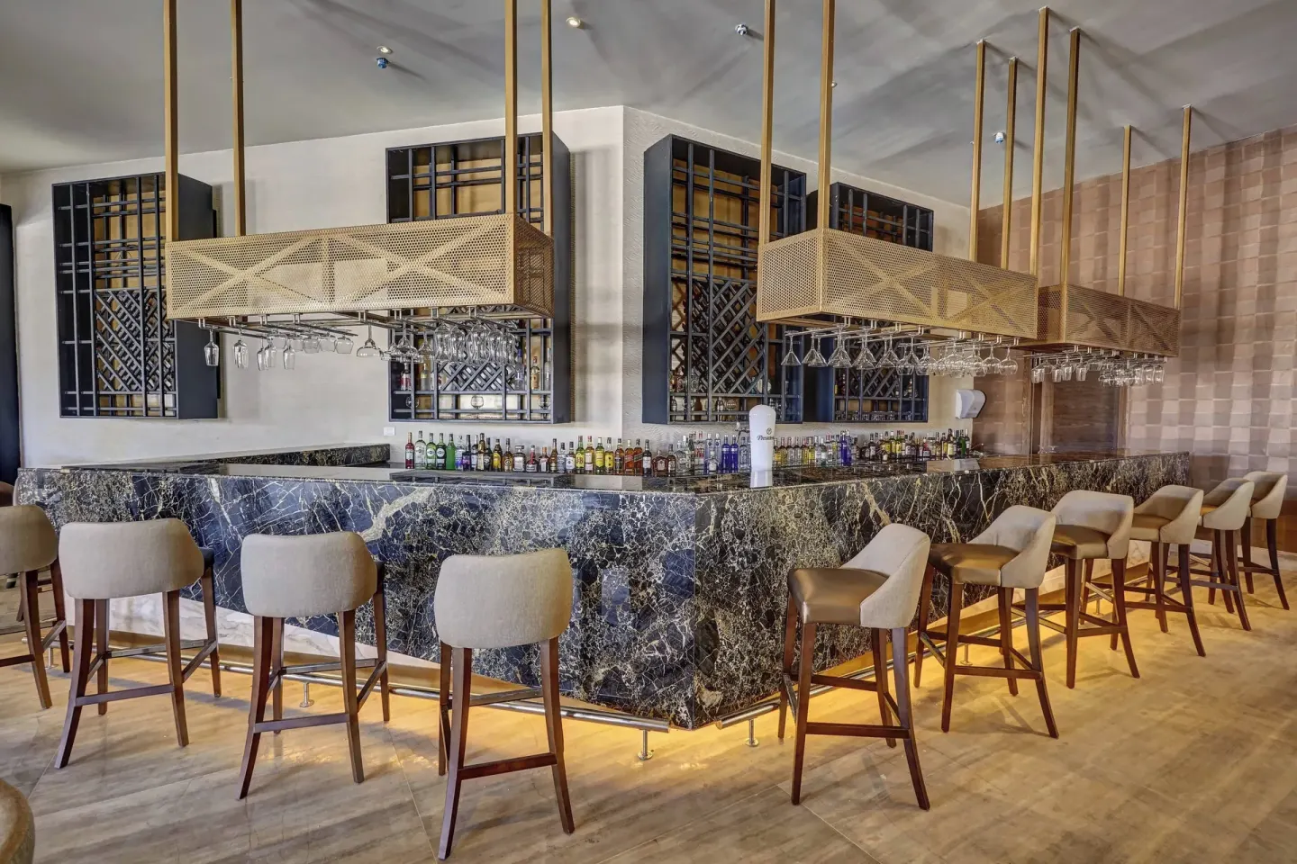 Marble bar counter with stools and bottle display at Royalton Bavaro Resort & Casino.