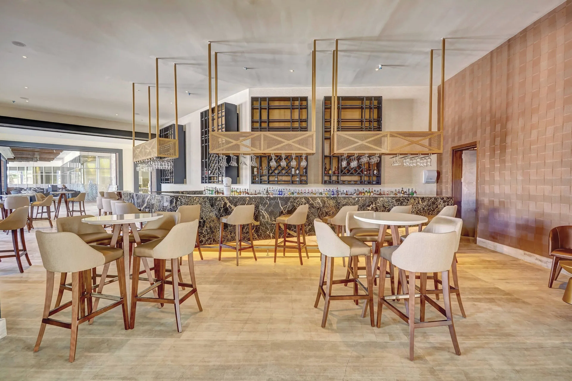Indoor bar seating area with round tables at Royalton Bavaro Resort & Casino.