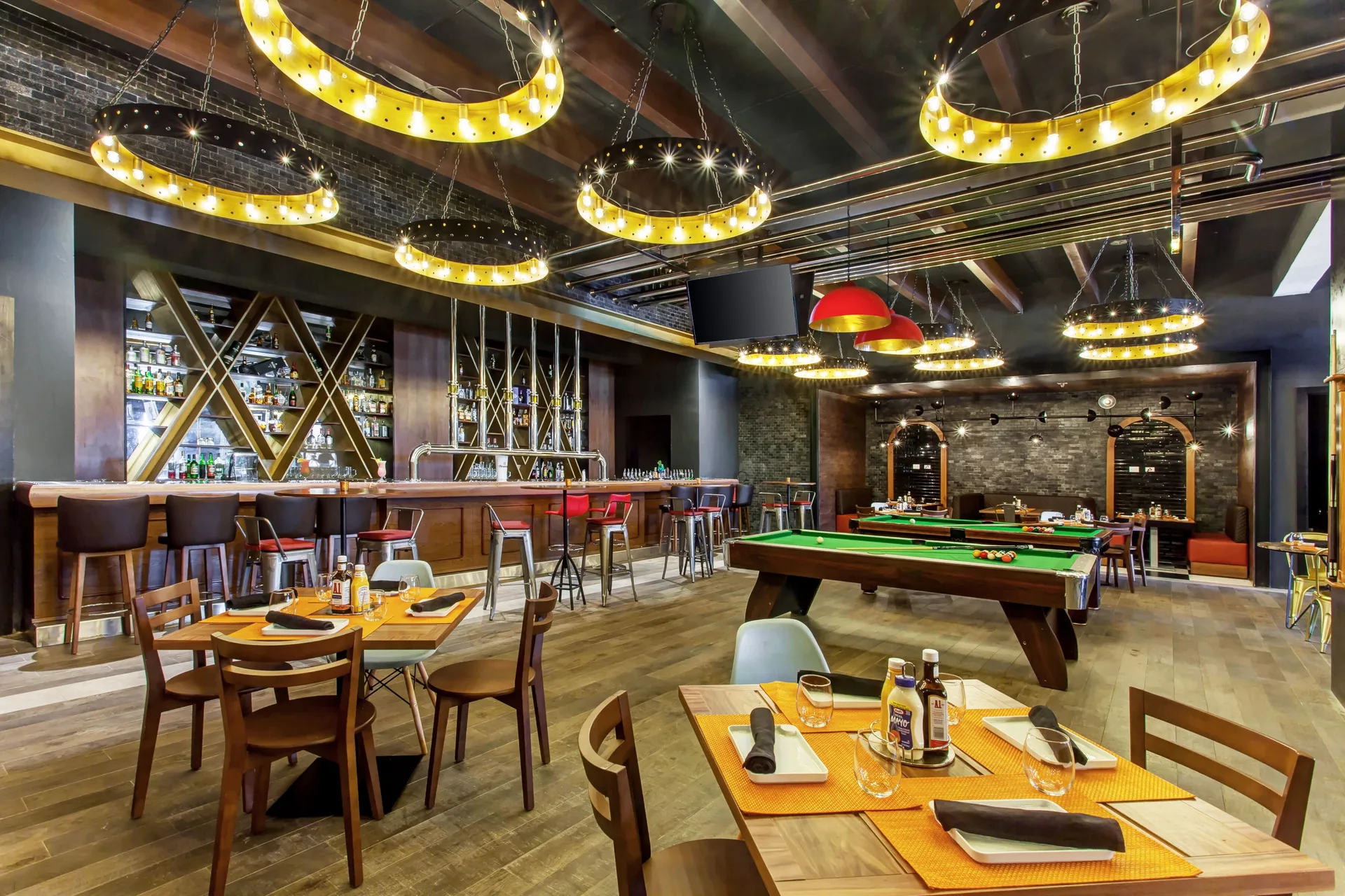 Sports bar with billiards, dining tables, and a long bar at Royalton Bavaro Resort & Casino.