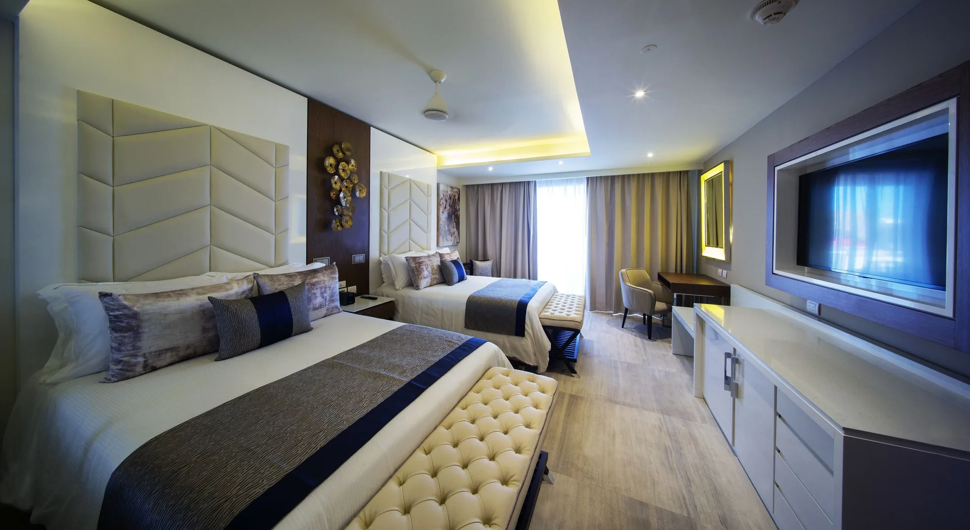 Two-bed guest room with TV and desk in the Chairman Suite at Royalton Bavaro Resort & Casino.