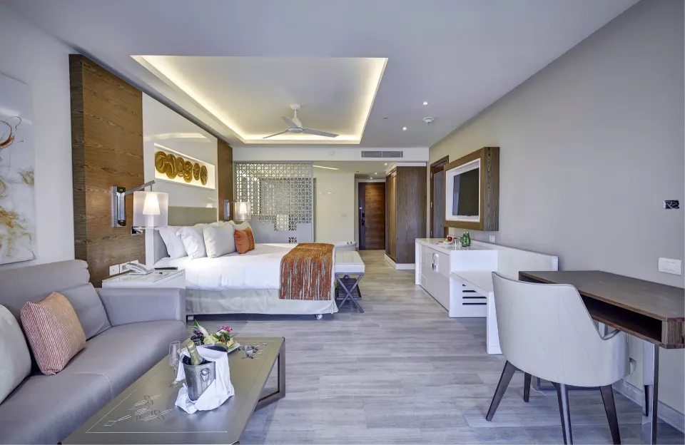 Luxury Junior Suite Swim Out king room with sofa and desk at Royalton Bavaro Resort & Casino.