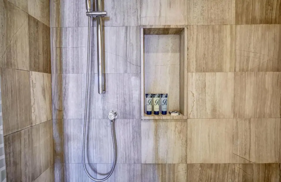 Luxury Junior Suite marble-tile shower with bath amenities at Royalton Bavaro Resort & Casino.