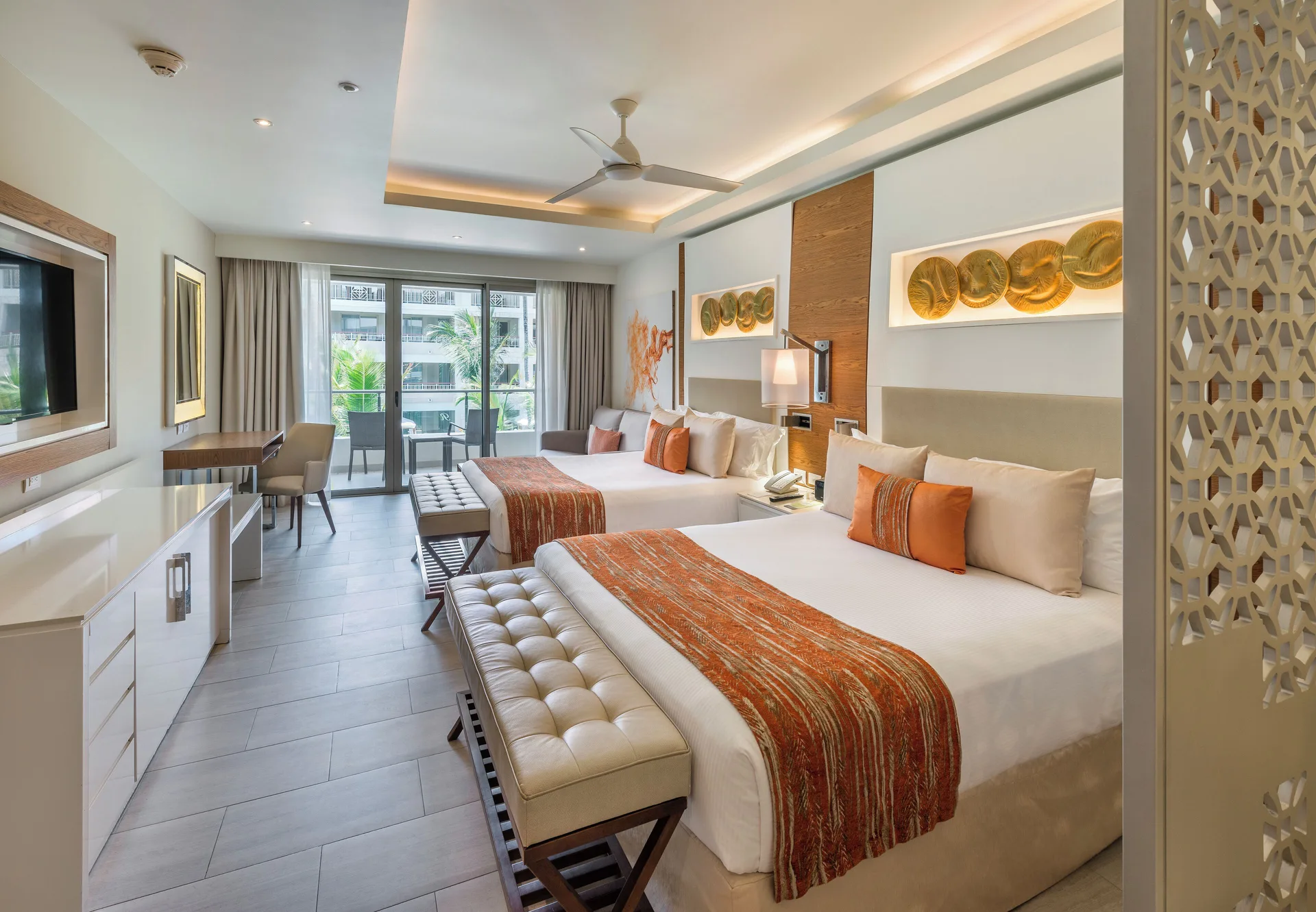 Luxury Junior Suite with two beds at Royalton Bavaro Resort & Casino, seating area, desk, and balcony.