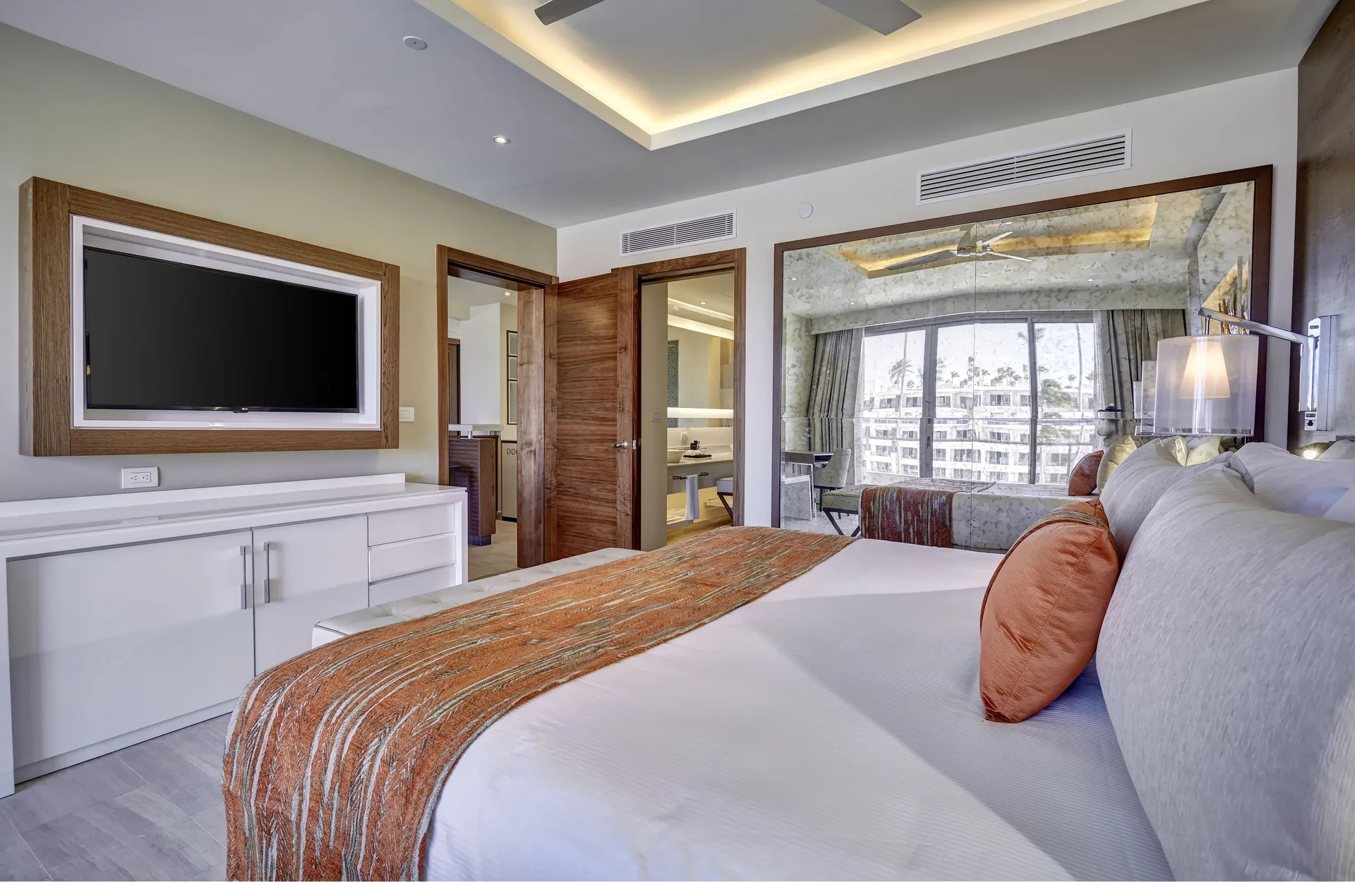 Luxury Presidential One Bedroom Suite bedroom TV and king bed at Royalton Bavaro Resort & Casino.