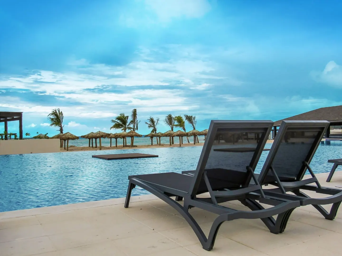 Pool loungers face the beach and ocean at Royalton Blue Waters Montego Bay.