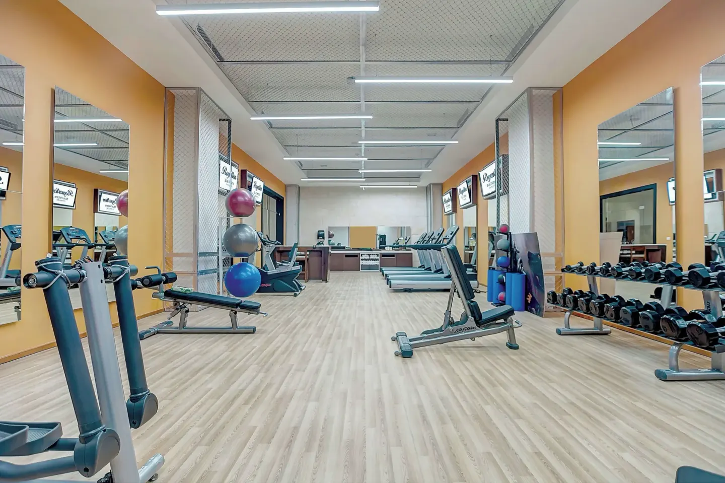 Fitness center with benches, dumbbells, mirrors, and cardio machines at Royalton Blue Waters Montego Bay.
