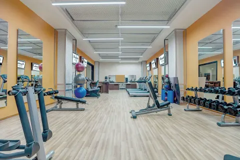 Fitness center with benches, dumbbells, mirrors, and cardio machines at Royalton Blue Waters Montego Bay.