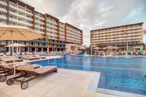 Resort pool with loungers, umbrellas, and guest room blocks at Royalton Blue Waters Montego Bay.