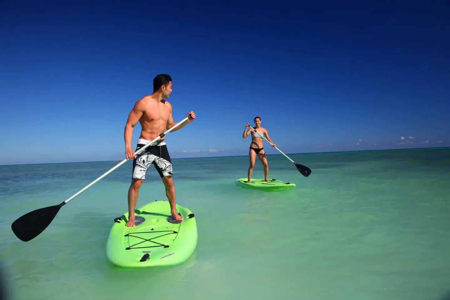 Guests paddleboarding on clear water at Royalton Blue Waters Montego Bay.