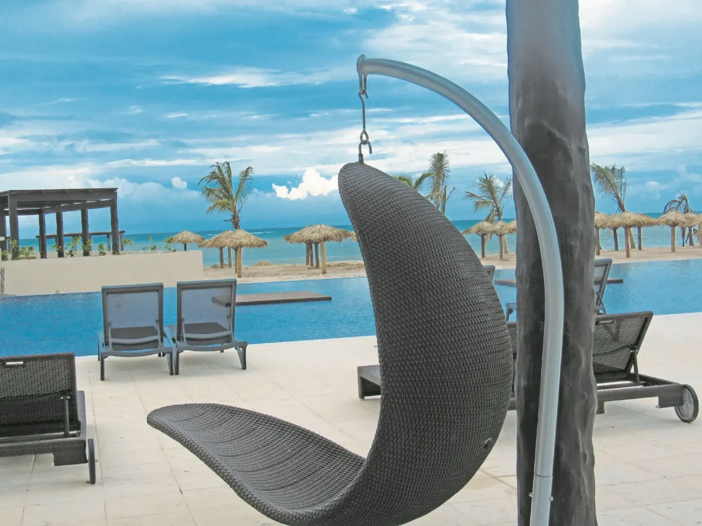 Hanging chair overlooks the pool, beach, and ocean at Royalton Blue Waters Montego Bay.